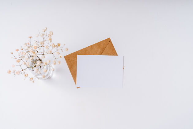 心手工艺纸信封内有白色空白纸条平面布置 俯视图带花的浪漫情书平面工作区邮件