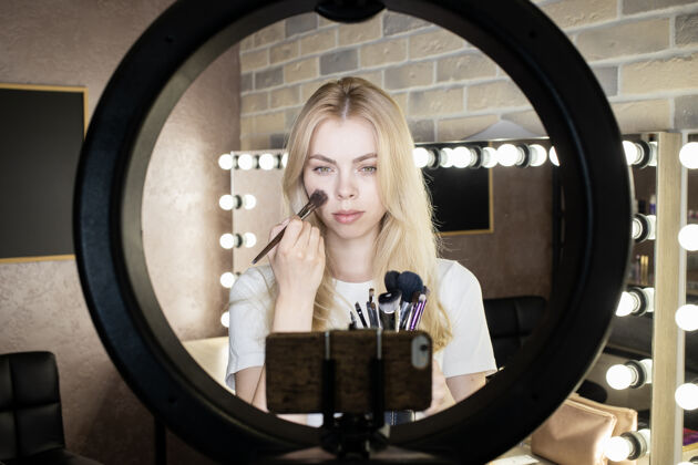 时尚一位年轻女子站在一盏彩灯前 在网上开设化妆课程博客互联网皮肤