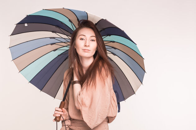 女人美丽的亚洲女人拿着彩色的伞在白色的表面时尚吻酷