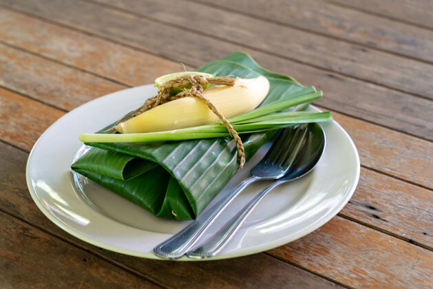 搅拌用香蕉叶包好的泰国菜在里面发球香蕉叶是泰国菜 泰国传统的虾仁炒面街道包装油炸