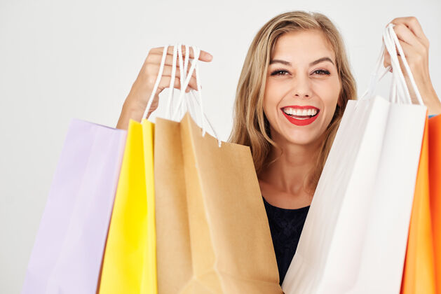 包快乐微笑的年轻女子展示购物袋购物满 孤立的白色纸袋快乐购买