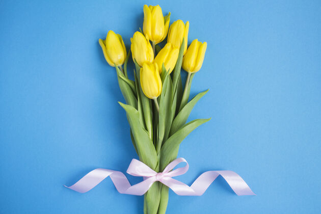 祝贺蓝色背景上的一束黄色郁金香春天郁金香花束