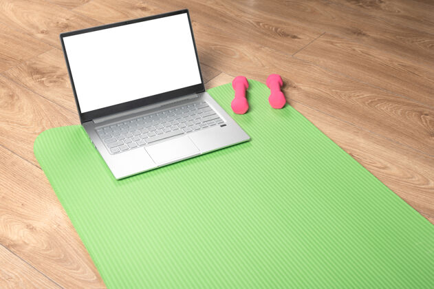 空白在线瑜伽健身 笔记本电脑模型木地板上有粉色的哑铃 健身垫和灰色的笔记本电脑在线训练概念生活方式计算机笔记本电脑