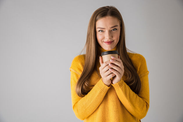 时尚一个美丽快乐的年轻女子隔着灰墙喝咖啡的画面饮酒女人咖啡