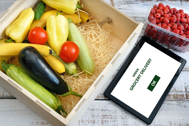 杂货店有机蔬菜和水果在木箱和平板电脑黄瓜食品客户