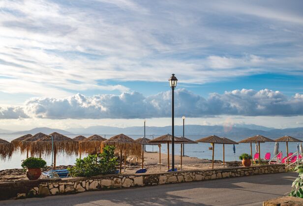 编辑美丽的爱奥尼亚海滩景观 五颜六色的躺椅和撑伞天气希腊语欧洲