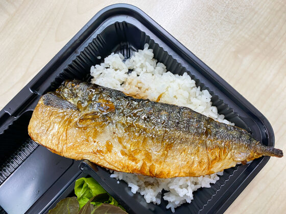 切片在塑料容器里的饭碗上放上烧有日本烧汁的萨巴鱼美食酱健康