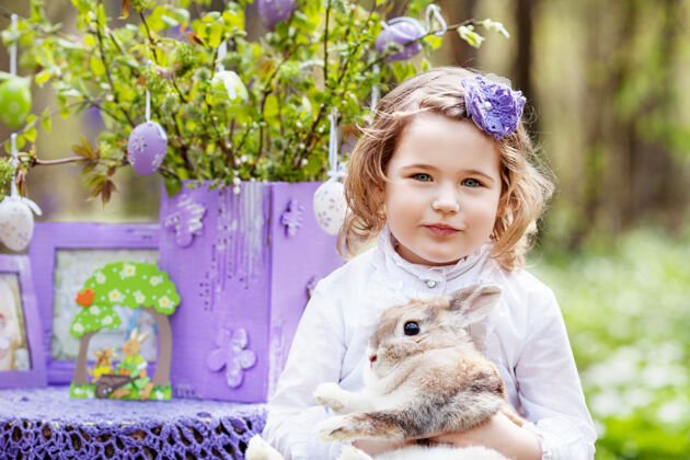 夏天小女孩在花园里玩真兔子花园大笑孩子和宠物在复活节彩蛋狩猎兔子春天带宠物的孩子们享受户外乐趣森林关怀花