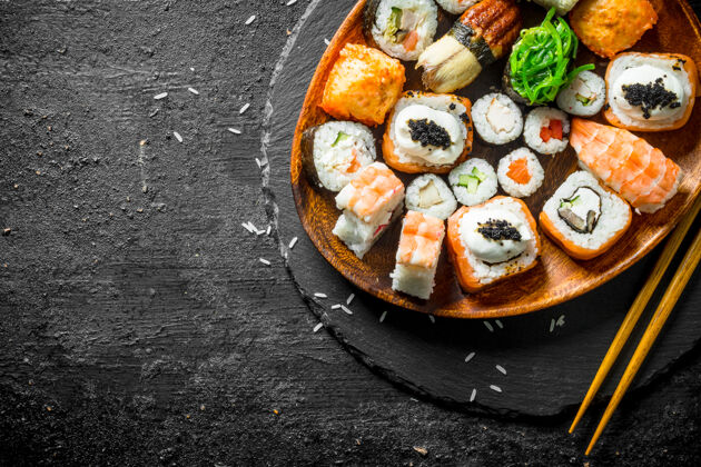 传统用筷子把各种寿司卷放在盘子里晚餐Maki日本