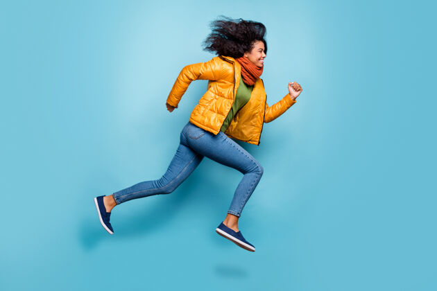 年轻深色皮肤的女士在蓝色背景上逃跑的照片非裔美国人多国外套