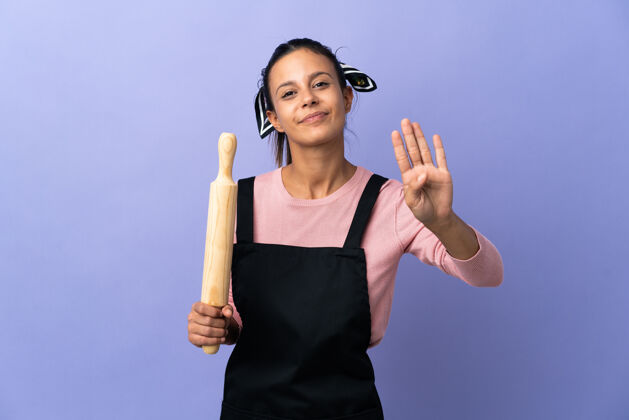 厨房穿着厨师制服的年轻女子高兴地用手指数着四个点工人面包