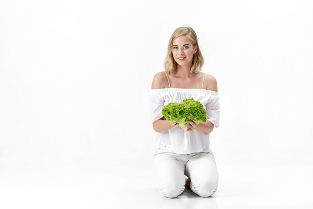 脸一个穿着白衬衫的金发美女拿着一份新鲜的蔬菜沙拉背景.健康还有节食营养模特微笑