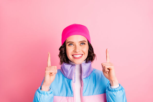 Recommendation好女人的照片表明举手空位穿暖色外套隔离粉红色背景GirlFemalSmile