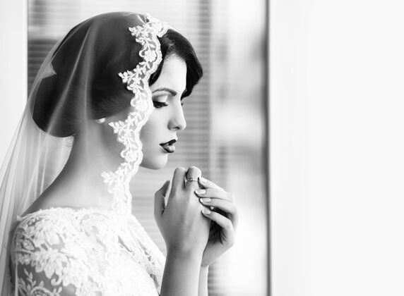 魅力美丽的年轻性感新娘 身穿白色蕾丝裙 头上戴面纱 手拉手靠近脸部新娘婚姻肖像