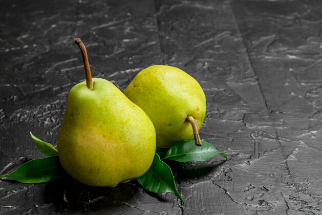 优良新鲜成熟的梨子和树叶放在木桌上吃树叶食物