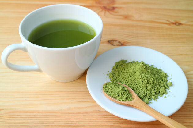 液体一杯热抹茶绿茶和一盘抹茶粉放在木桌上抗氧化剂饮料维生素