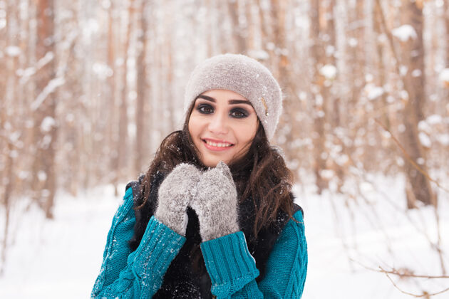 女孩在阳光明媚的日子里 年轻漂亮的女人在冬天的雪地公园里散步魅力黑发微笑