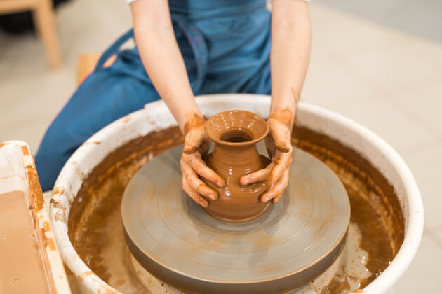 孩子漂亮的小女孩在陶艺作坊里做陶罐碗陶瓷