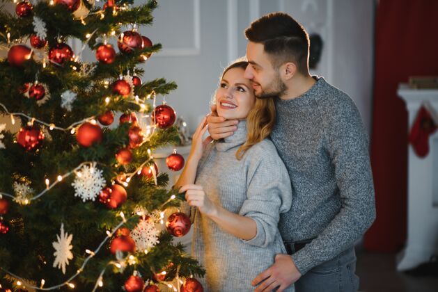 圣诞节恋爱中的情侣一起度过平安夜 为他们的浪漫感到幸福室内浪漫拥抱