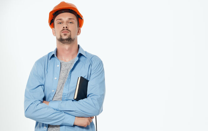 工作男性建筑师戴着橙色安全帽 工作着灰色裁剪的风景建筑手安全