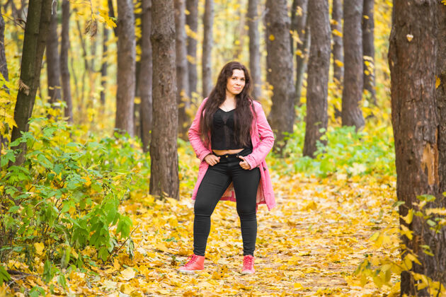 快乐秋天 自然和人的概念-公园里穿着粉色夹克的大码女人的肖像季节现代黑发