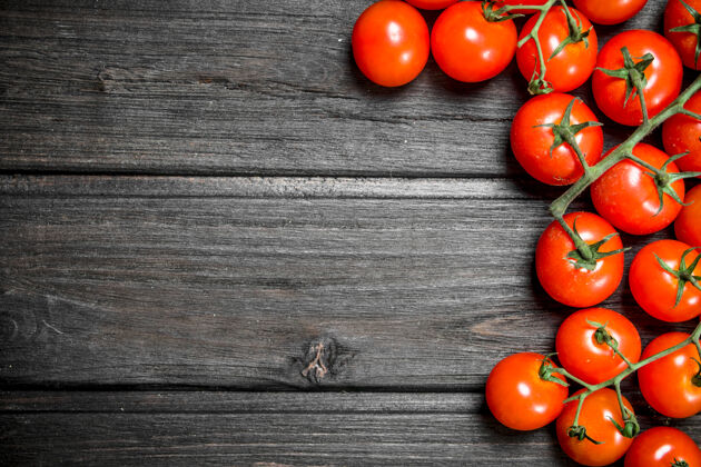 圆红色的西红柿放在桌子上分支机构木制背景素食物体新鲜