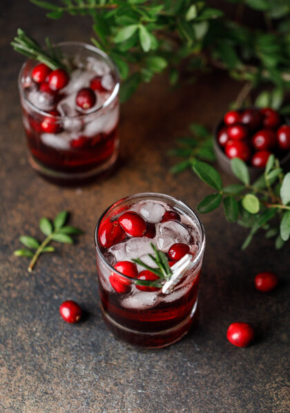 冰红莓鸡尾酒冰圣诞节红莓饮料在玻璃装饰糖和迷迭香玻璃自制饮料
