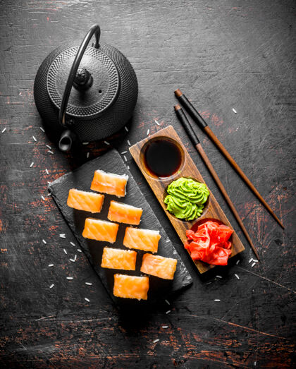 日本费城寿司卷放在石头架子上 上面放着姜 芥末和酱油食品金枪鱼料理