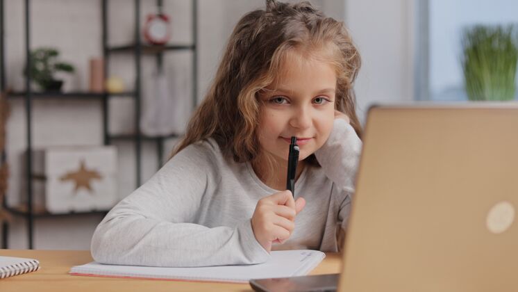 电脑可爱的小学生在家用笔记本电脑学习计算机距离学习 家庭教育课程在线交流