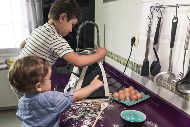 父母两个孩子在用厨房机器人做煎饼成熟烹饪帮助