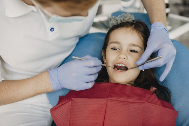 牙科可爱的小女孩坐在口腔科的座位上 由儿科牙医检查牙齿牙痛美丽初级