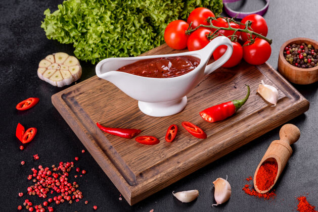 美味格鲁吉亚菜的辛辣调味料阿吉卡在一个碗里 用红辣椒和大蒜放在混凝土桌上特写镜头营养小吃健康
