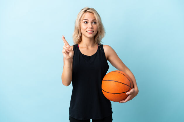 等待年轻的俄罗斯女子打篮球孤立的蓝色与手指交叉和祝愿最好的立志身体球员