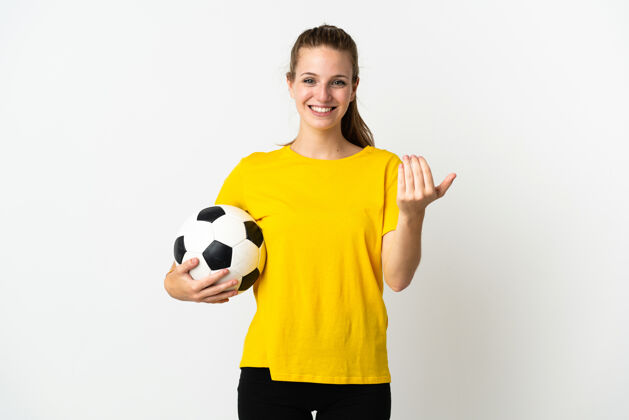 空白年轻的白种人女子 拿着足球 做着迎面而来的手势 被隔离在白色背景下运动邀请球
