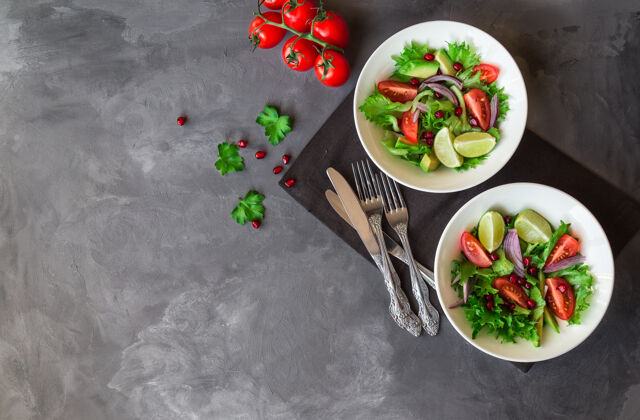 健康新鲜健康的沙拉 番茄 鳄梨和石榴在灰色的碗里混凝土.副本空间面积有机午餐鳄梨