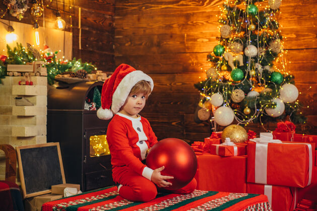 季节困惑的孩子穿着圣诞老人的衣服 装饰圣诞节圣诞树概念圣诞孩子的梦想举行童年微笑