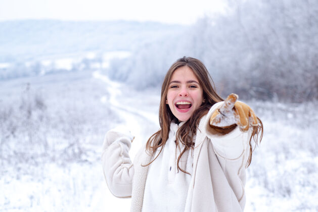 天气快乐的雪球游戏冬天玩冬天有雪有乐趣公园活动微笑的女孩在冬季旅行天帽子快乐