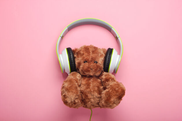 音乐泰迪熊与立体声耳机粉红色粉彩表面孩子有声读物泰迪