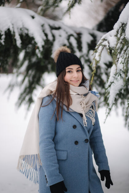 爱冬天的雪天 穿着蓝色外套的漂亮女人在树林里散步微笑美丽雪橇