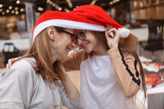女学生特写母女欢笑 抚摸额头 戴圣诞老人帽帽子庆祝传统