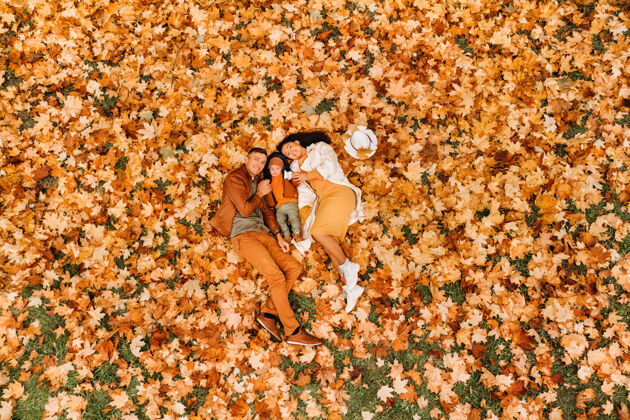 散步一家人在公园里秋天躺在地上健康秋季自然女人