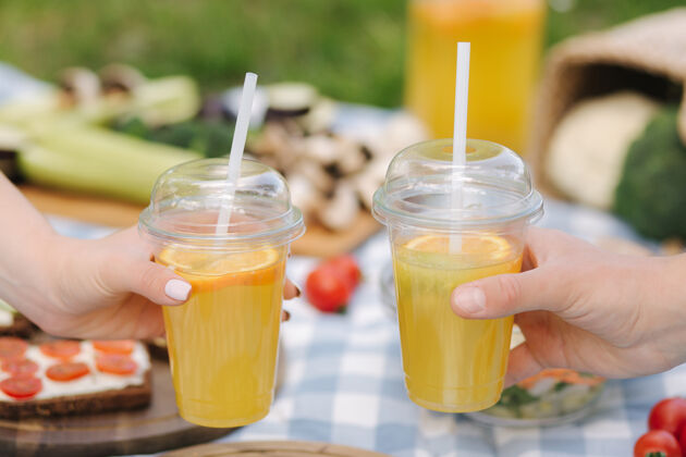 咖啡户外素食野餐前两只手拿橘子柠檬水的照片鳄梨酱鳄梨新鲜