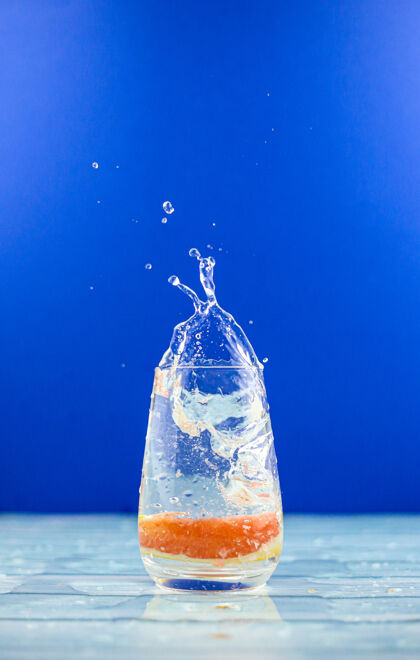 水橘子片掉了下来 溅到了一杯清水里清晰鸡尾酒玻璃