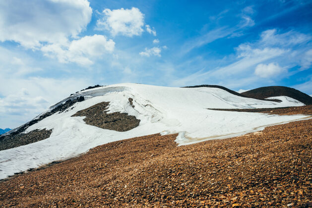 景观美丽的小冰川 在多云的岩石山上有冰檐口天空雪在山上高山冒险小