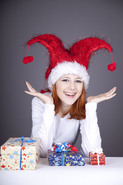 玩一个戴着圣诞帽的红发女孩惊喜地拿着礼物盒女人内衣红发