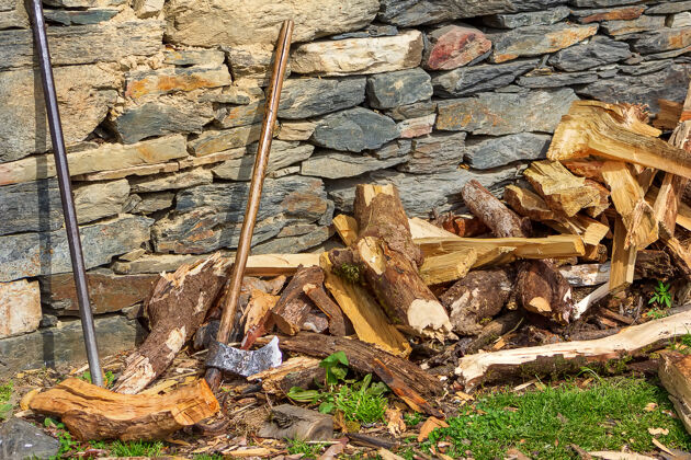 斧头一把木斧 一根金属棒 挨着石墙 劈柴伐木工人木柴乡下