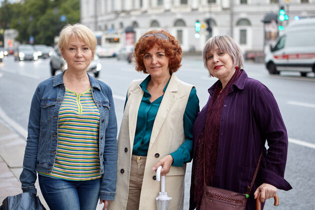 女人三个穿着休闲服的白人中年妇女站在城市街道上散步50岁活力奶奶