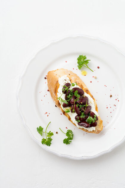 生的用红豆 大蒜 橄榄油和凝乳奶酪在白色表面做三明治早餐烹饪食物