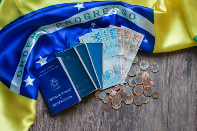 工作巴西文件和社会保障文件以及巴西国旗上的巴西货币工作卡储蓄经济危机