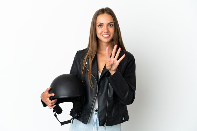 司机戴着摩托车头盔的女人在孤立的白色背景下快乐地用手指数着四个漂亮空白摩托车手